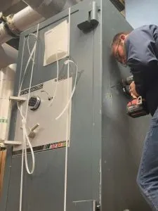 locksmith drilling a large safe during a service call